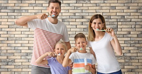 A family holds their toothbrushes